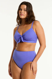 A model wearing the Panelled High Waist Pant in colour Iris (Blue), from the front, cropped image