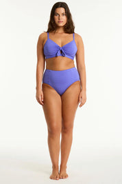 A model wearing the Panelled High Waist Pant in colour Iris (Blue), from the front, showing the whole outfit