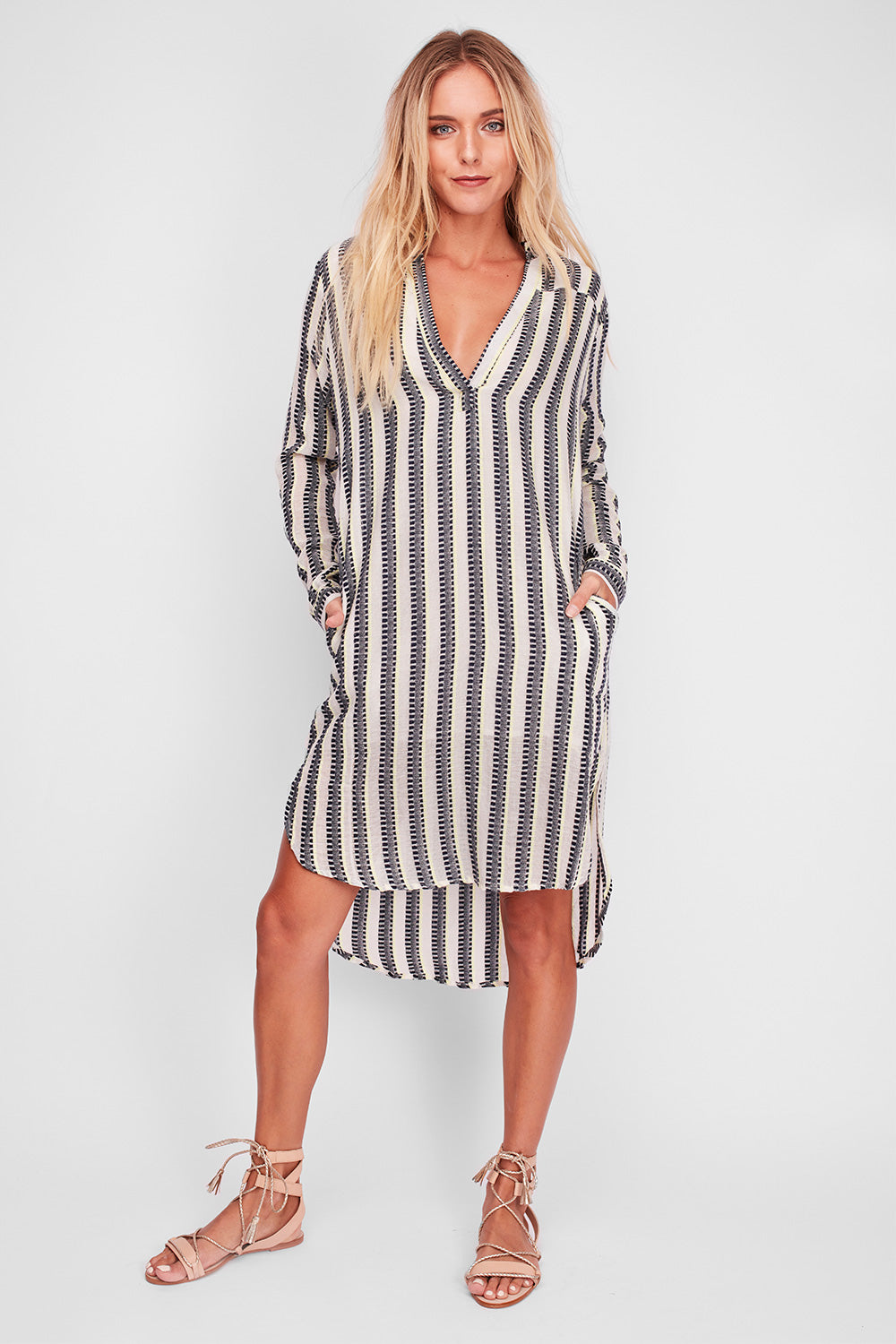 A model wearing the Andros Dress in colour Stripe (White), from the front, showing the whole outfit