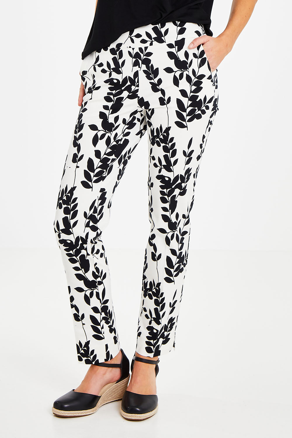 Model Courtney wearing size 8 of the Ankle Pull On Pants With Pockets in colour Floral (Black), from the front, cropped image