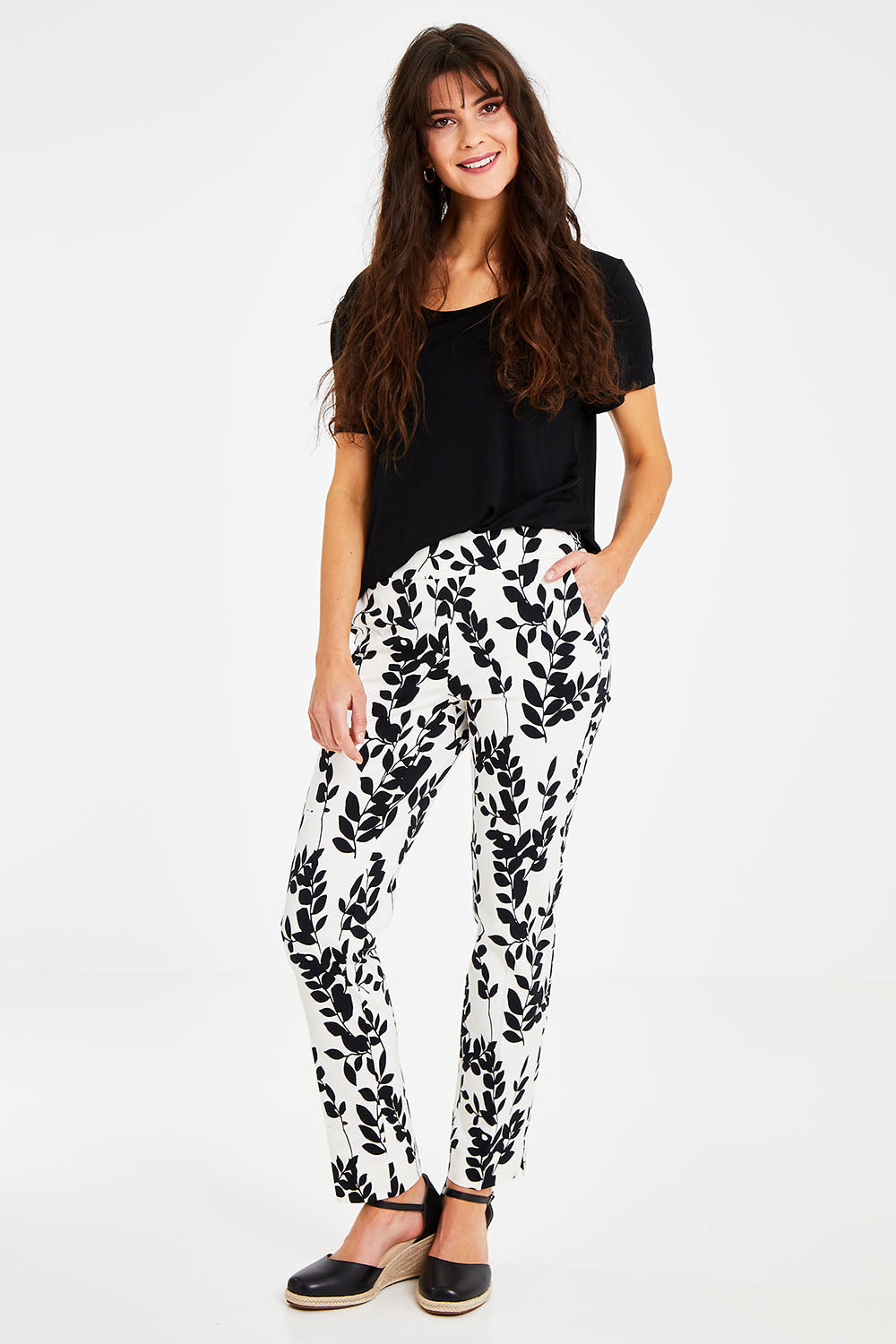 Model Courtney wearing size 8 of the Ankle Pull On Pants With Pockets in colour Floral (Black), from the front, showing the whole outfit