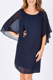 Model Emma wearing size 10 of the Butterfly Chiffon Dress in colour Navy (Blue), from the front, cropped image