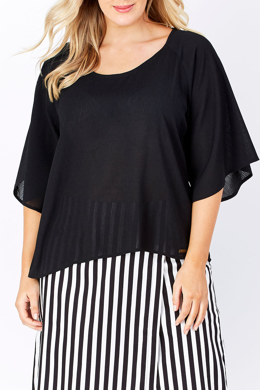Model Jess wearing the Farreras Blouse in colour Black (Black), from the front, cropped image