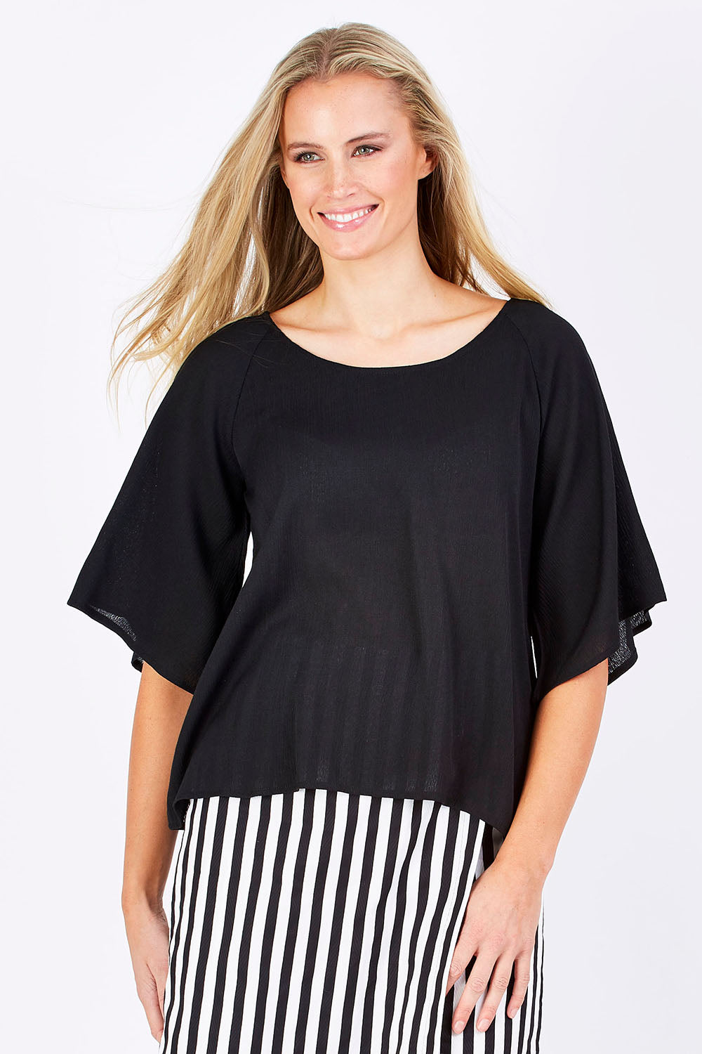 Model Maddy wearing the Farreras Blouse in colour Black (Black), from the front, cropped image