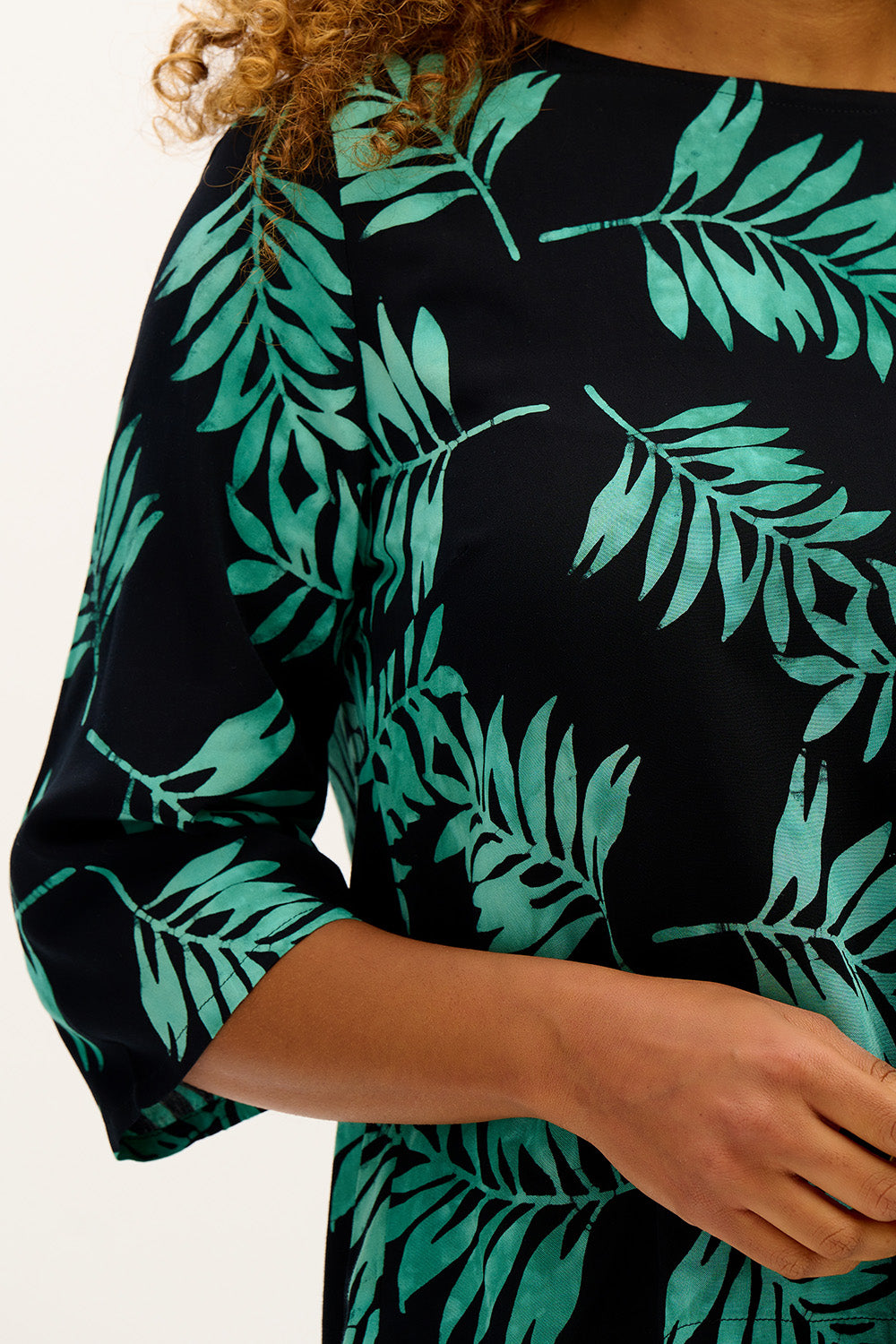 A model wearing the Casey Batik Top in colour Blkgreen (Black), from the front, cropped image