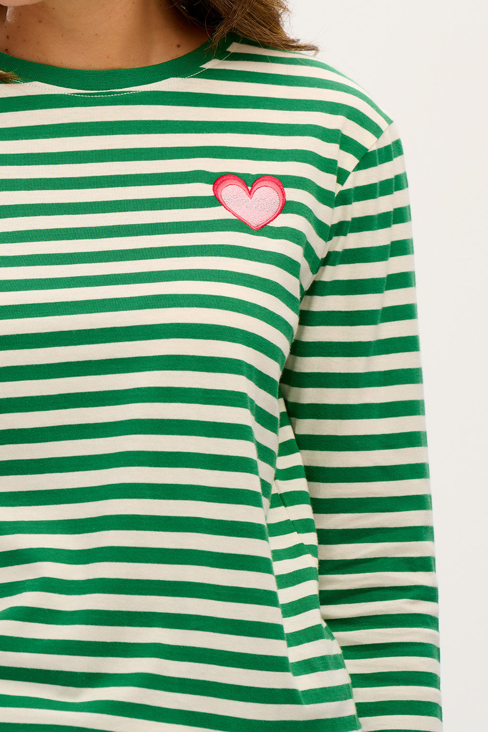 A model wearing the Brunswick Jersey Top in colour Greenwht (Green), from the front, cropped image