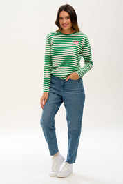 A model wearing the Brunswick Jersey Top in colour Greenwht (Green), from the front, showing the whole outfit