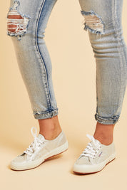 A model wearing size 37 of the Lamew Metallic Sneaker in colour Silver (Metallics), from the front, cropped image
