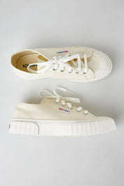 A model wearing size 37 of the 2630 Stripe Platform Sneaker in colour Beigenat, from the front, showing the whole outfit