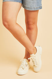 A model wearing size 38 of the 2630 Stripe Platform Sneaker in colour Beigenat, from the front, cropped image