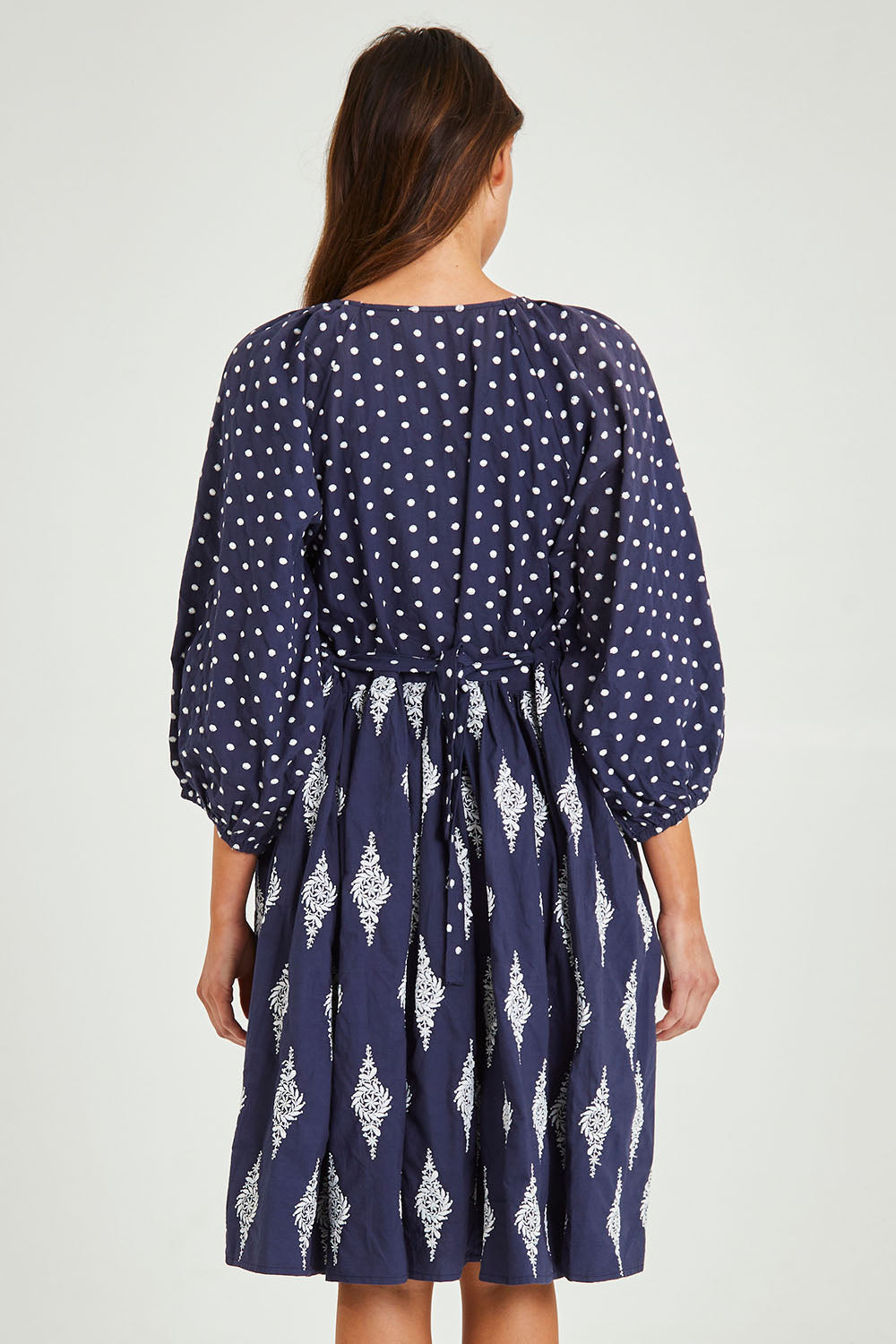 Model Madeline wearing size S of the Gaia Dress in colour Navy (Blue), from the back