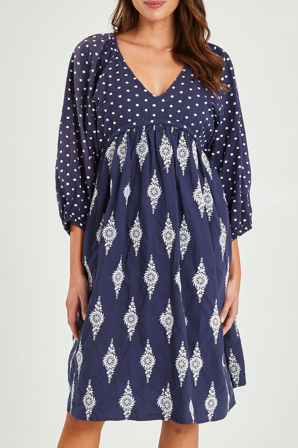 Model Madeline wearing size S of the Gaia Dress in colour Navy (Blue), from the front, cropped image