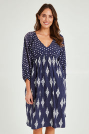 Model Madeline wearing size S of the Gaia Dress in colour Navy (Blue), from the front, cropped image