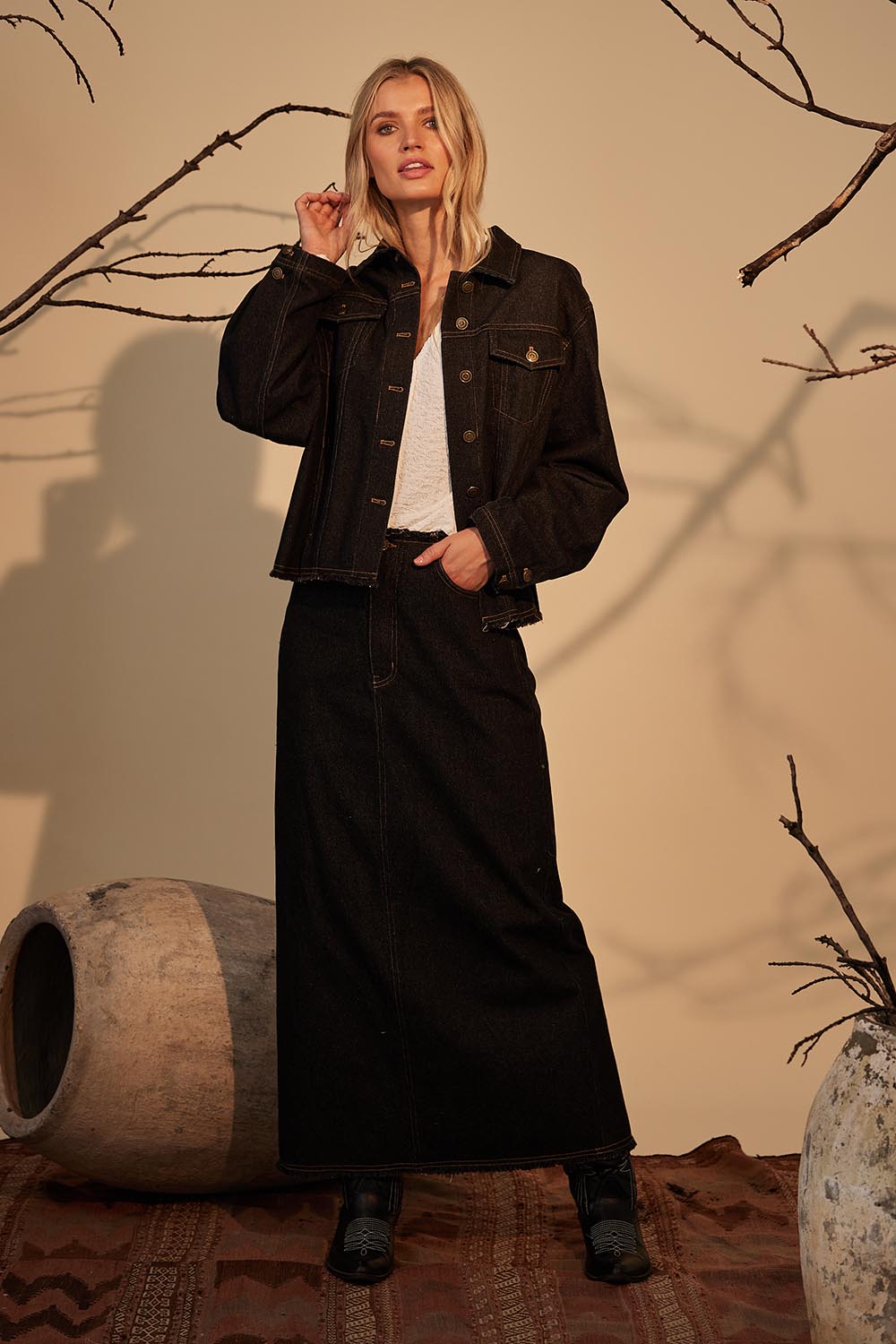 A model wearing the Macey Skirt in colour Blackwash (Black), from the front, showing the whole outfit