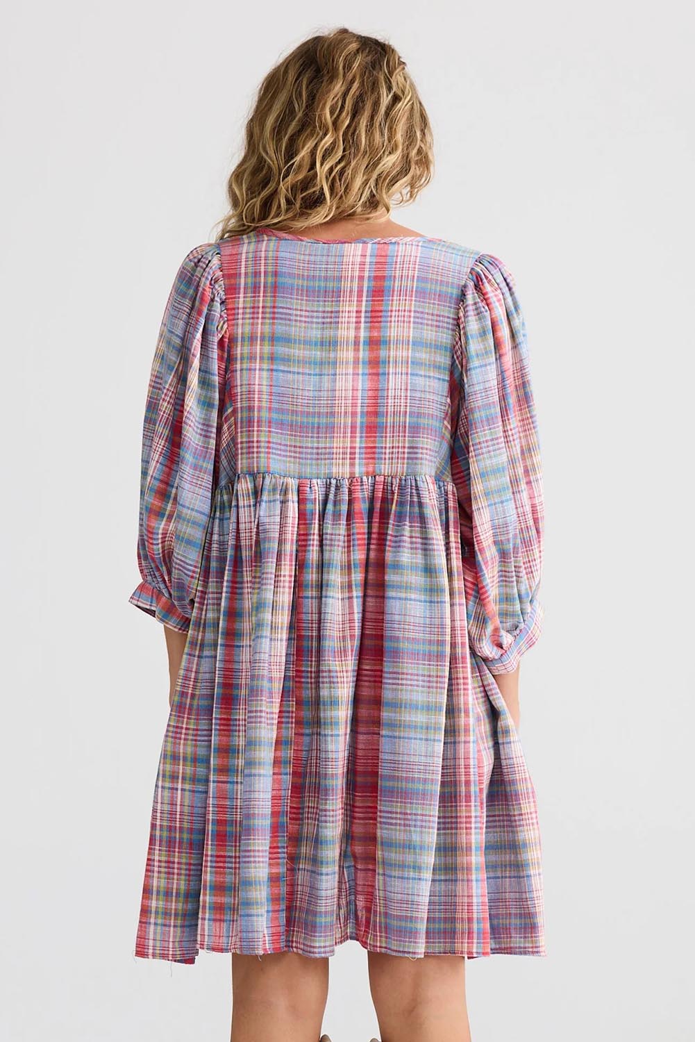 A model wearing the Winnie Cotton Mini Dress in colour Picnicchec (Pink), from the back