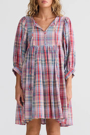A model wearing the Winnie Cotton Mini Dress in colour Picnicchec (Pink), from the front, cropped image