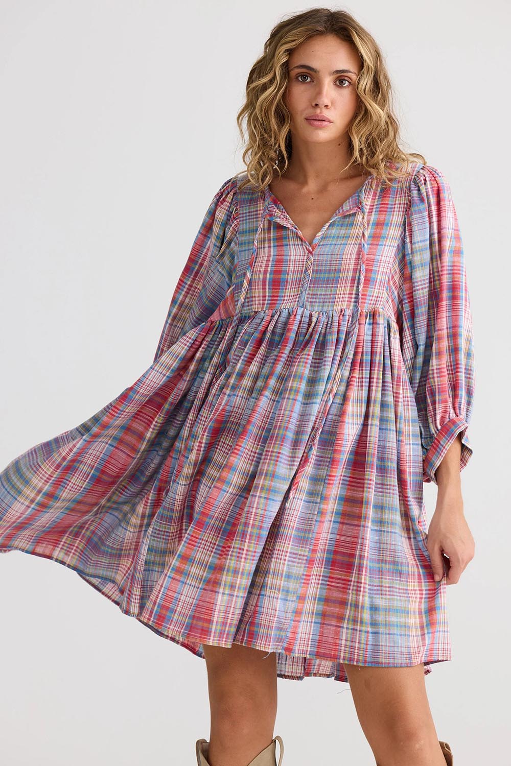 A model wearing the Winnie Cotton Mini Dress in colour Picnicchec (Pink), from the front, cropped image