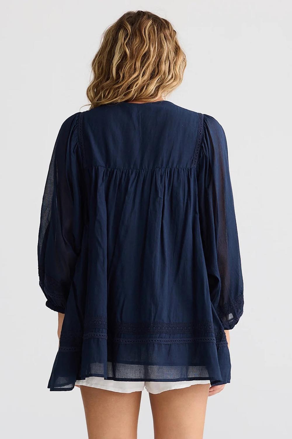 A model wearing the Solstice Cotton Blouse in colour Navy (Blue), from the back