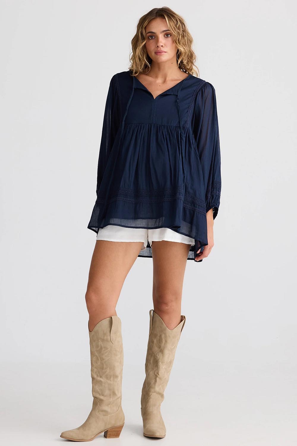 A model wearing the Solstice Cotton Blouse in colour Navy (Blue), from the front, showing the whole outfit