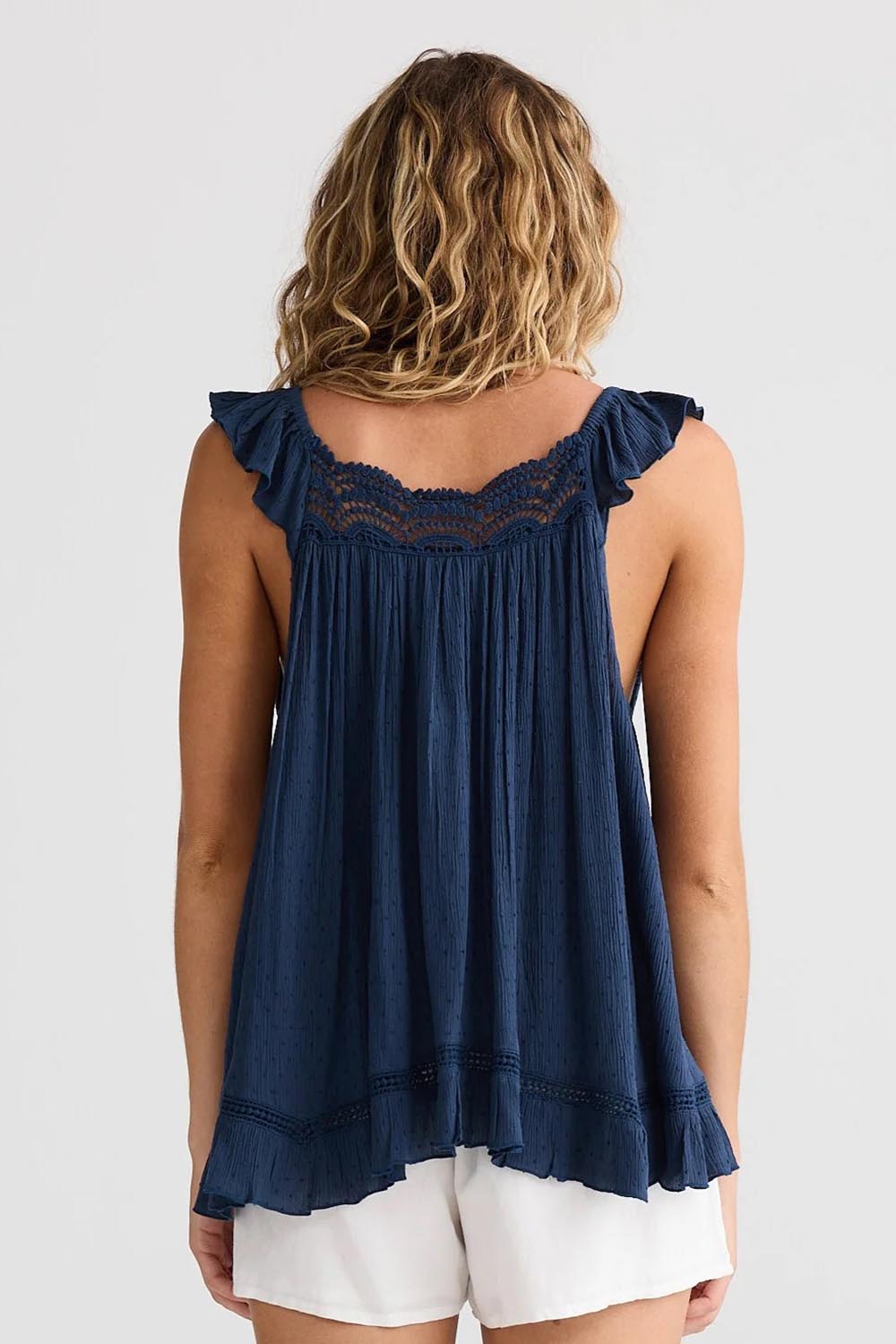 A model wearing the Exhale Cami in colour Navy (Blue), from the back