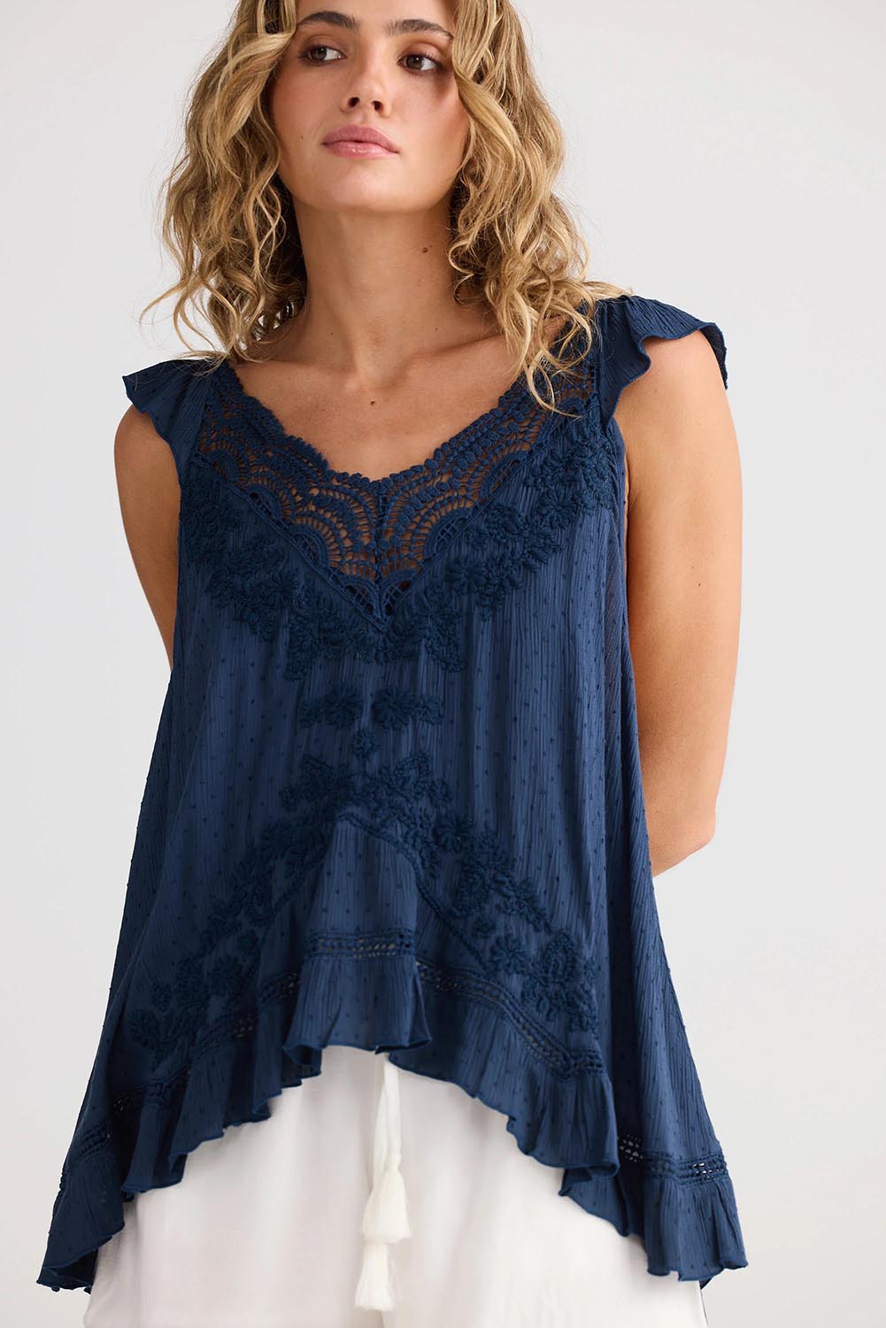 A model wearing the Exhale Cami in colour Navy (Blue), from the front, cropped image