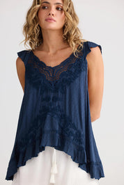 A model wearing the Exhale Cami in colour Navy (Blue), from the front, cropped image