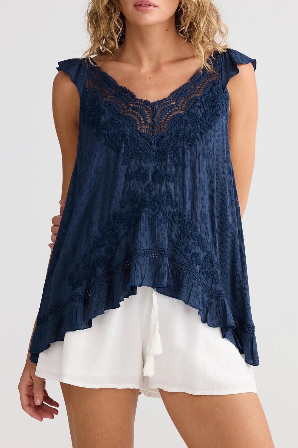 A model wearing the Exhale Cami in colour Navy (Blue), from the front, cropped image