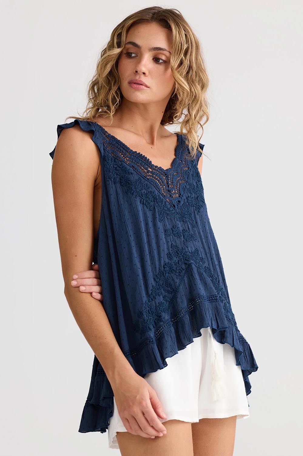 A model wearing the Exhale Cami in colour Navy (Blue), from the front, cropped image