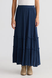 A model wearing the Inhale Maxi Skirt in colour Navy (Blue), from the front, cropped image
