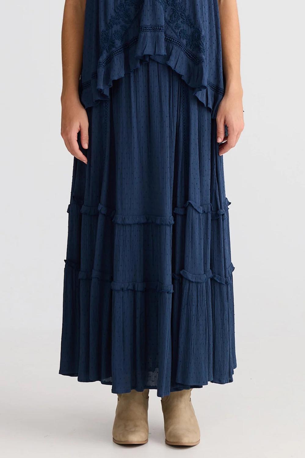 A model wearing the Inhale Maxi Skirt in colour Navy (Blue), from the front, cropped image