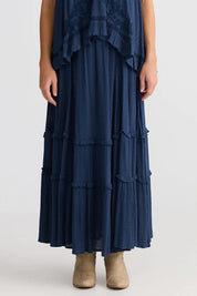 A model wearing the Inhale Maxi Skirt in colour Navy (Blue), from the front, cropped image