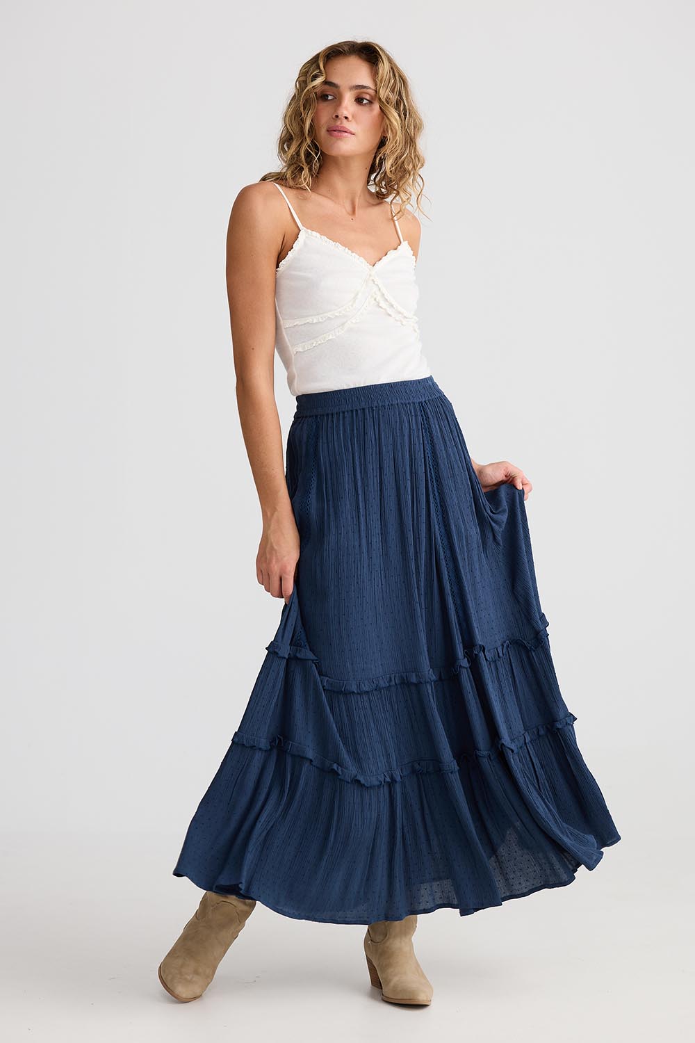 A model wearing the Inhale Maxi Skirt in colour Navy (Blue), from the front, showing the whole outfit