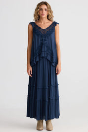 A model wearing the Inhale Maxi Skirt in colour Navy (Blue), from the front, showing the whole outfit