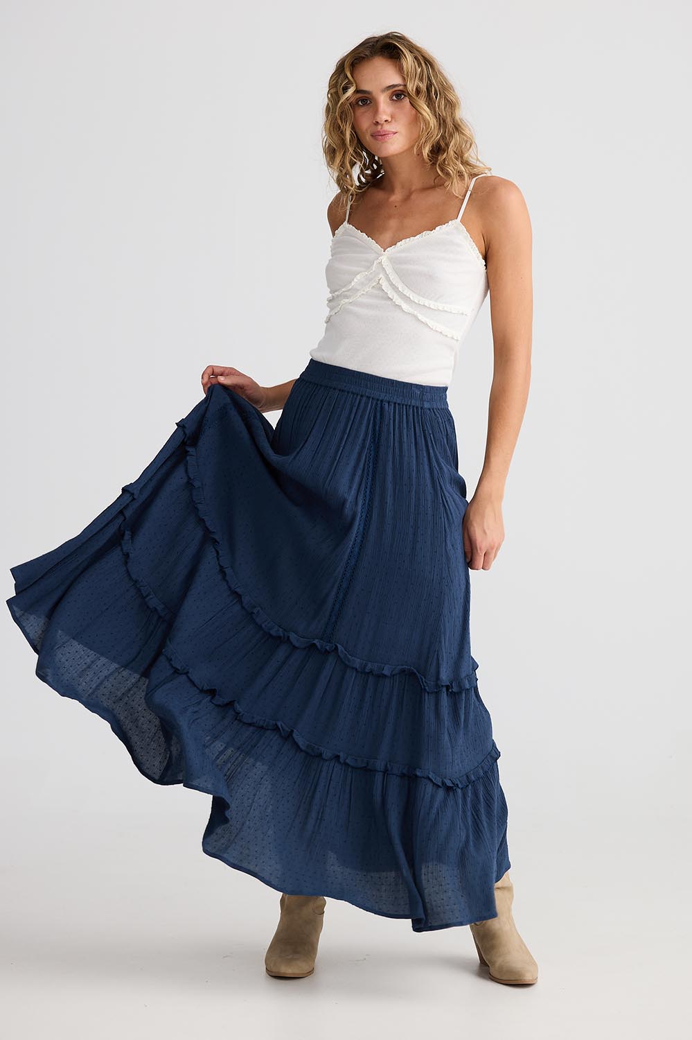 A model wearing the Inhale Maxi Skirt in colour Navy (Blue), from the front, showing the whole outfit