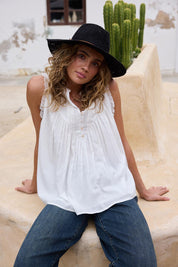 A model wearing the Sprite Cotton Sleeveless Top in colour White (White), from the front, showing the whole outfit