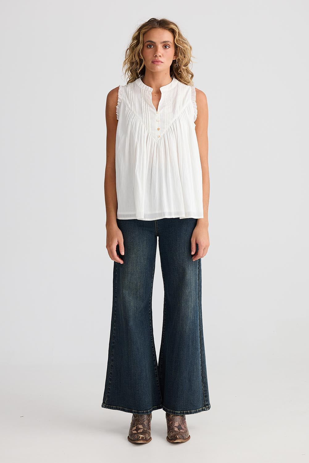 A model wearing the Sprite Cotton Sleeveless Top in colour White (White), from the front, showing the whole outfit