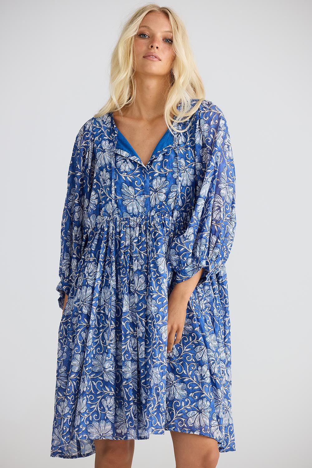 A model wearing the Wisteria Cotton Mini Dress in colour Blueblosso (Blue), from the front, cropped image