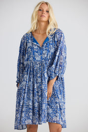 A model wearing the Wisteria Cotton Mini Dress in colour Blueblosso (Blue), from the front, cropped image
