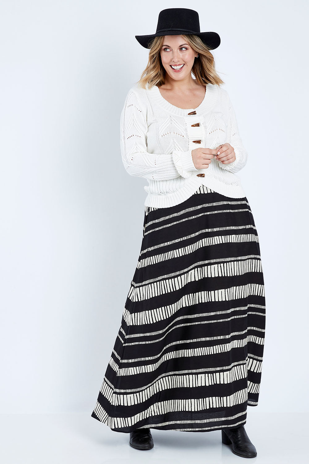 Model Jess wearing size 14 of the Rosie Maxi Skirt in colour Sandstone (Black), from the front, showing the whole outfit