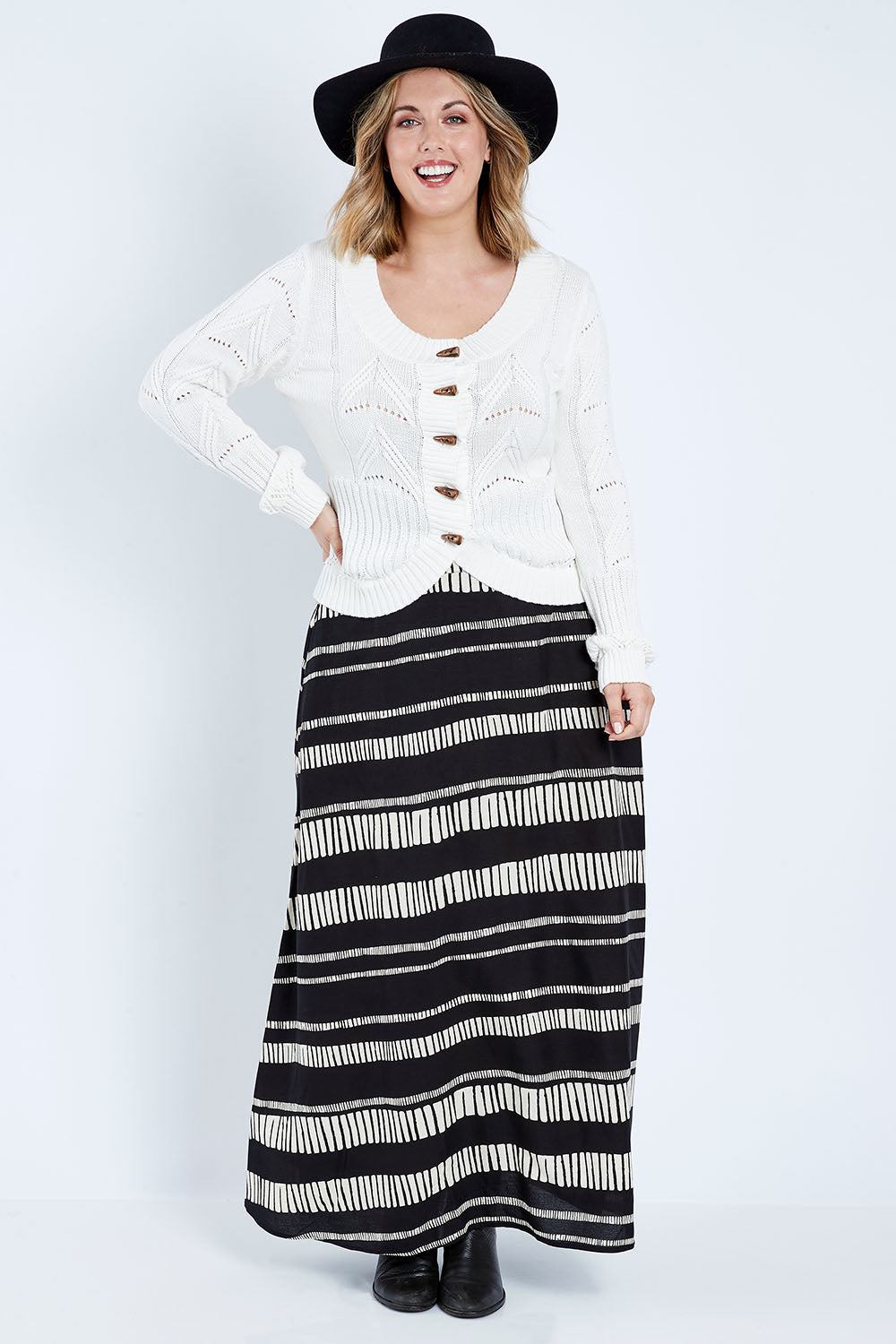 Model Jess wearing size 14 of the Rosie Maxi Skirt in colour Sandstone (Black), from the front, showing the whole outfit