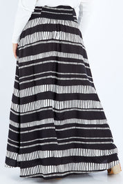 Model Sasha-Lee wearing size 16 of the Rosie Maxi Skirt in colour Sandstone (Black), from the back