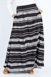 Model Sasha-Lee wearing size 16 of the Rosie Maxi Skirt in colour Sandstone (Black), from the front, cropped image