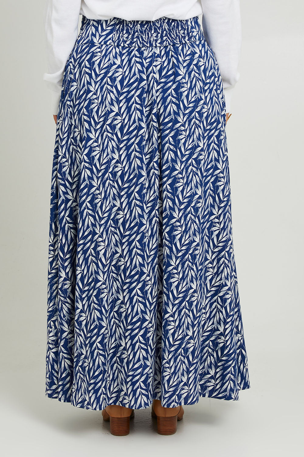 Model Monique wearing size 14 of the Rosie Maxi Skirt in colour Forest (Blue), from the back