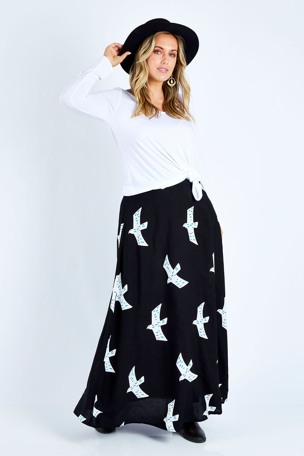 Model Jess wearing size 14 of the Rose Maxi Skirt in colour Birdflight (Black), from the front, showing the whole outfit