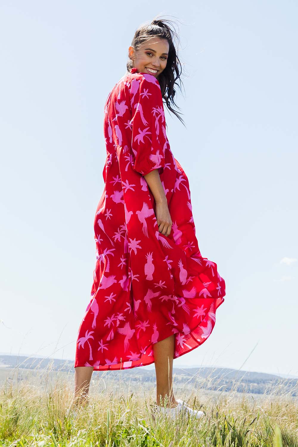 Model Vitoria wearing size 10 of the Alice Gathered Dress in colour Bird (Red), from the front, showing the whole outfit