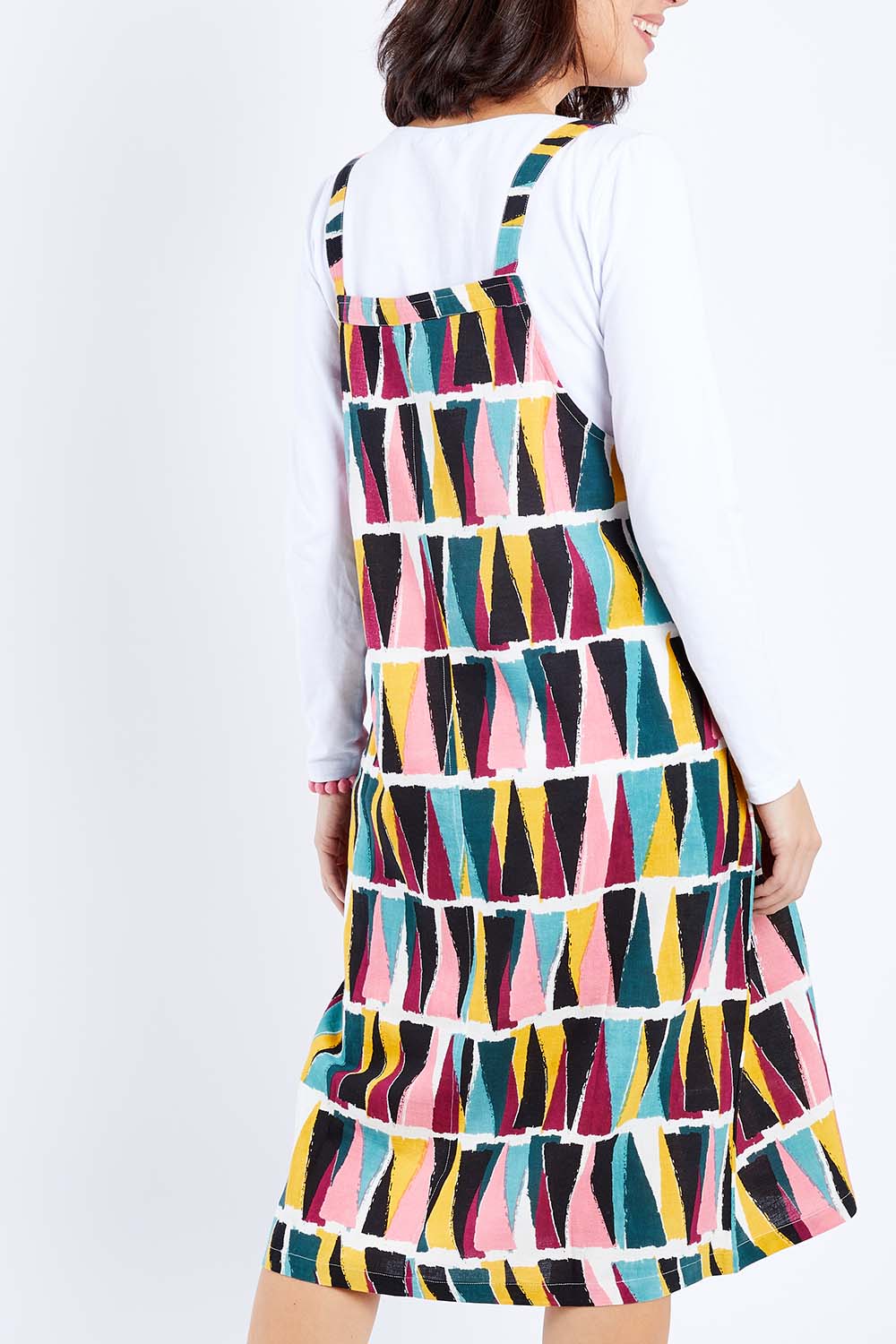 Model Andrea wearing size 10 of the Charlotte A Line Pinafore Dress in colour Mountains (Blue), from the back