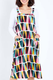 Model Andrea wearing size 10 of the Charlotte A Line Pinafore Dress in colour Mountains (Blue), from the front, cropped image