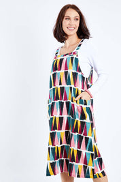 Model Andrea wearing size 10 of the Charlotte A Line Pinafore Dress in colour Mountains (Blue), from the front, cropped image