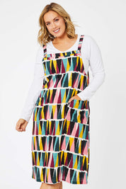 Model Jess wearing size 14 of the Charlotte A Line Pinafore Dress in colour Mountains (Blue), from the front, cropped image