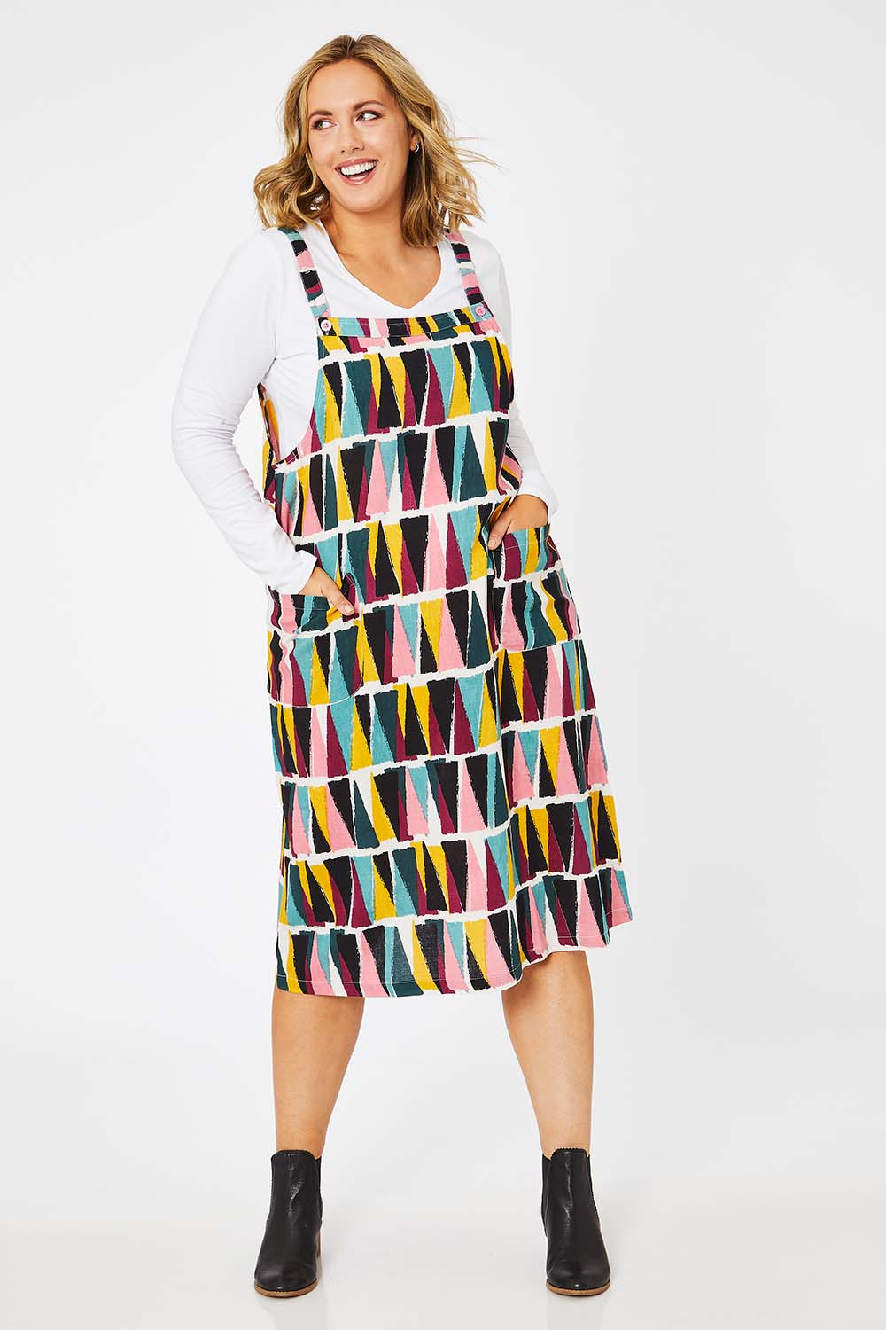 Model Jess wearing size 14 of the Charlotte A Line Pinafore Dress in colour Mountains (Blue), from the front, showing the whole outfit